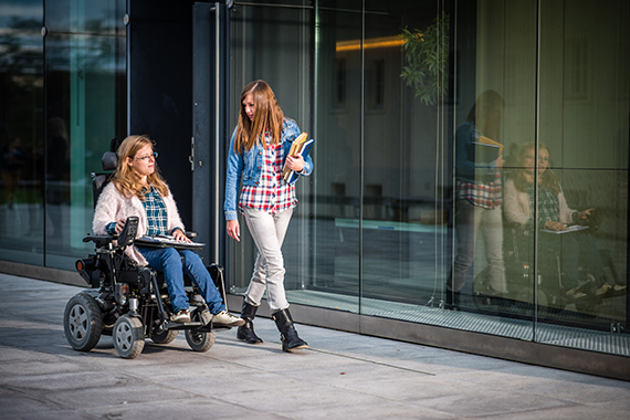 Student in a wheelchair with an assistant