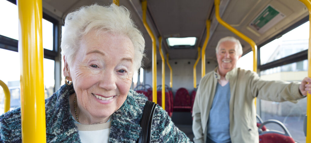 Close-up portrait of senior woman standing on bus.
